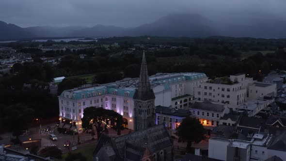 Historic Stone Church with Tall Tower and Luxury Hotel Building with Illuminated Facade alt