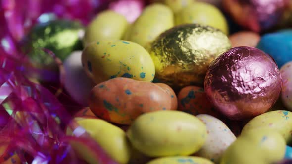 Rotating shot of colorful Easter candies on a bed of easter grass - EASTER alt