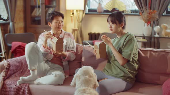 Asian Women Eating Food from Carton Boxes at Home alt