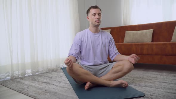 A Man Does Meditation at Home in the Lotus Position the Practice of Conscious Breathing