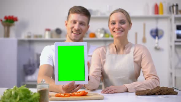 Couple Holding Tablet With Green Screen, Showing Thumbs Up, Delicious Recipe App alt