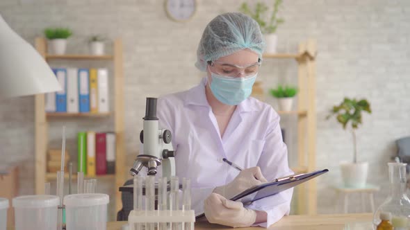 Close Up of a Female Laboratory Assistant Conducts and Records the Study Using a Microscope alt
