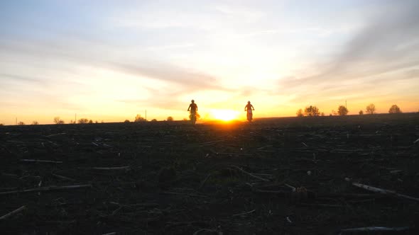 Silhouette of Two Motorcyclists Riding on Their Motorbikes From Sunset. Men Having Active Rest alt