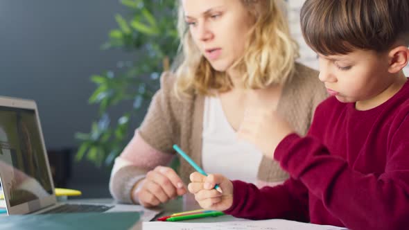 Video of mom helping her son during online classes. Shot with RED helium camera in 8K. alt