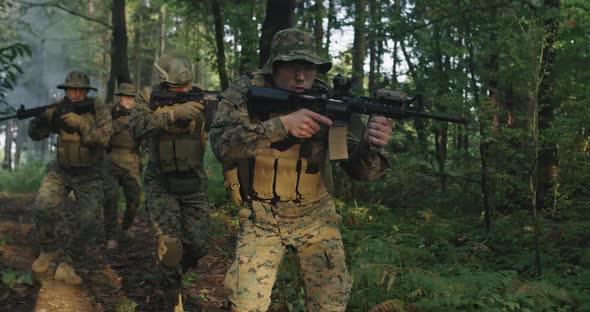 Soldiers Squad in the Smoke Moving in Battle Operation Through Dense Forest alt