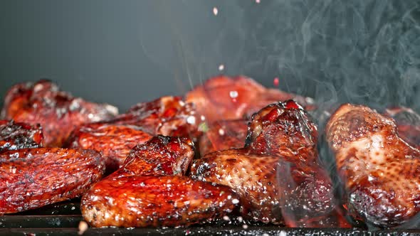 Super Slow Motion Shot of Seasoning Falling on Fresh Grilled Chicken Wings at 1000 Fps alt