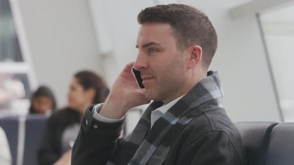 Business man talking on cell phone at airport