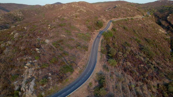 Drone Of Cars Driving Along Empty Winding Road alt
