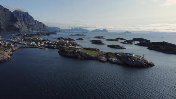 Flying at the coast of Henningsvaer overlooking the many connected islands of Henningsvaer and the f alt
