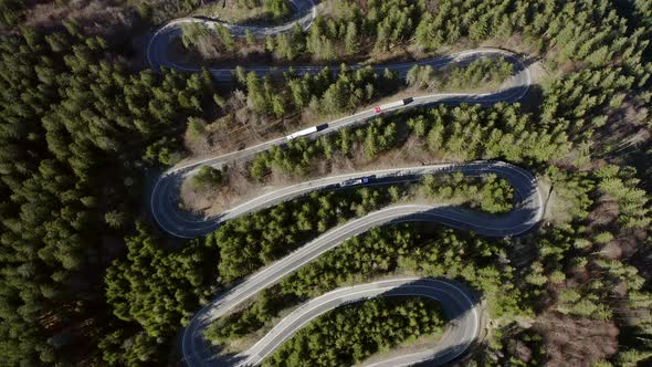 Top View Of The Vehicles Turning At The Serpentine Road Of Bratocea Pass In Romania. aerial alt