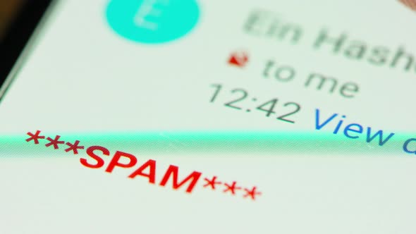 close up of hand browsing through spam emails on a smartphone screen alt