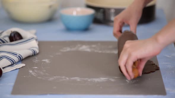 Baker putting chocolate dough at the form for baking while making pie.