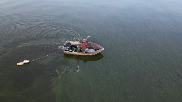 A Fisherman in a Boat Catches Fish in the Sea