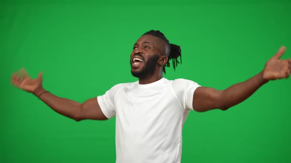 Portrait of Inspired Excited African American Sportsman Gesturing Victory on Green Screen Looking alt
