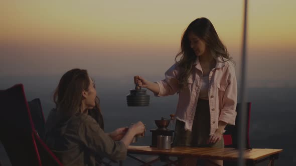 Young Asian woman pours coffee into a coffee cup alt
