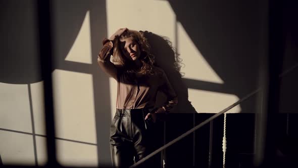 Beautiful European Girl in a Silk Shirt in the Sun Looks at the Camera