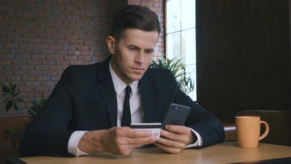 Business Man Online Banking Using Smartphone Shopping Online With Credit Card Sitting in Modern alt