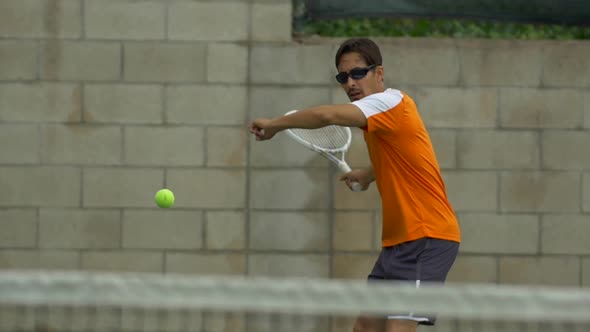 Two men playing outdoor tennis together. alt