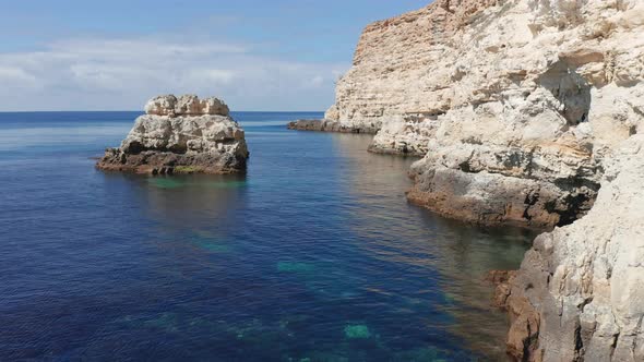 Fly Above Sea Surface Between Rocks