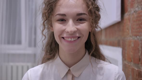 Portrait of Smiling Young Female Sitting and Working on Laptop alt