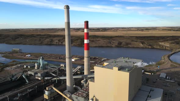 Aerial 4k circle around coal and gas powered generating station in rural USA countryside next to riv alt