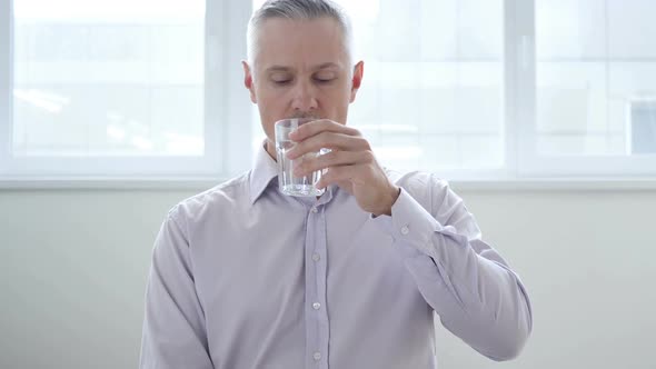 Businessman Drinking Water in Office alt