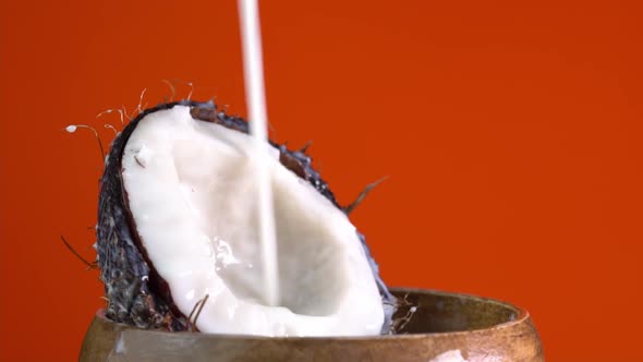 Making cocktail of fruits, drinking cold lemonade. Cracked fresh coconut with splashing milk. alt