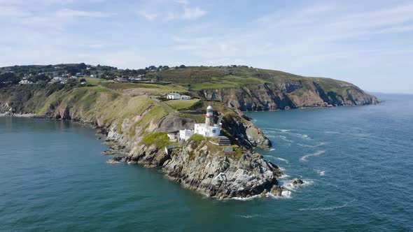 Flying around The Baily Lighthouse at Howth Head during a sunny day. alt