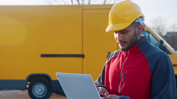 Indian Engineer Wearing Safety Helmet Holding Laptop  Checking His Planned Work alt