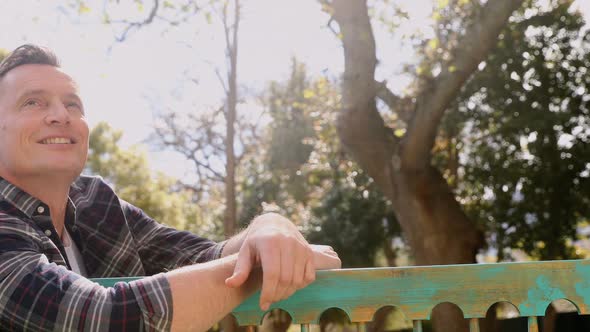 Mature man sitting on a bench in the garden 4k alt