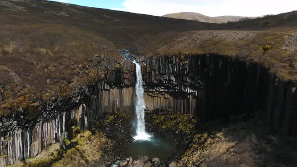 Aerial View of the Svartifoss Waterfall Surrounded By Basalt Columns in Iceland alt