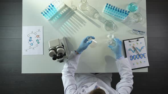 Chemistry Student Mixing Chemical Agents in Flask, Conducting Color Experiments alt