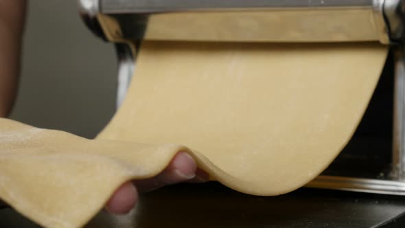 Chromed kitchen pasta machine on the table 4K 2160p 30fps UltraHD footage - Dough processing  for It alt