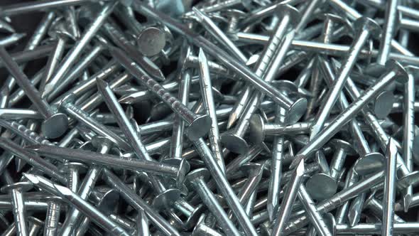 A Pile of Metallic Silver Nails for Construction Work Rotate As a Background Hobnails are Spinning alt