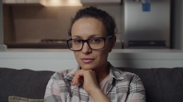 Woman in Eyeglasses Propping Chin Hand Looking Thoughtfully at Camera alt