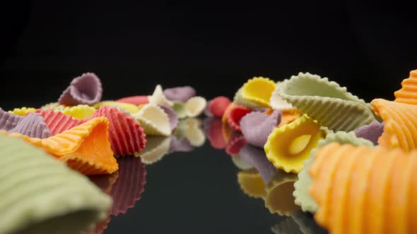 Creative Multicolored Pasta Farfalle on a Black Background in Perspective Background