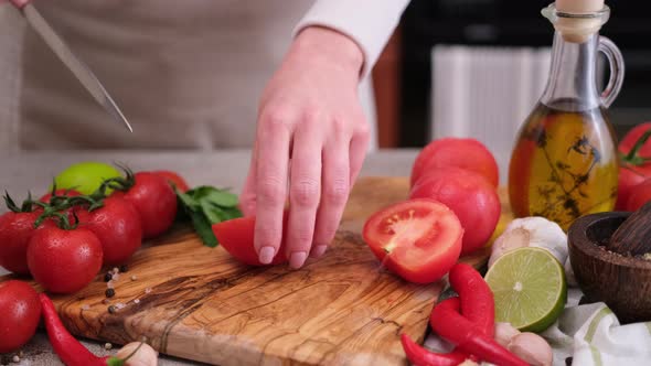 Woman Cutting Peeled Tomato Using Kitchen Knife alt