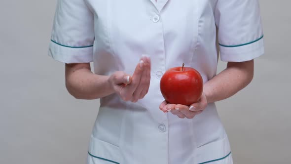 Nutritionist Doctor Healthy Lifestyle Concept - Holding Red Apple and Medicine or Vitamin Pill alt