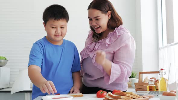 Overweight mom and son make a sandwich salads for dieting weight loss together. healthy food