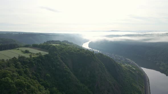 Steep sloping river valley on a sunny and misty morning near Cochem, Zell. Wide angle fly over drone alt