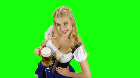 Bavarian Girl in Bavarian Costume Holding a Glass of Beer and Laughs. Green Screen alt