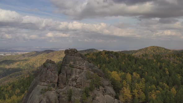 Aerial View of a Group of Tourists on Top of a High Cliff in the Autumn Forest, Free Solo Climbing
