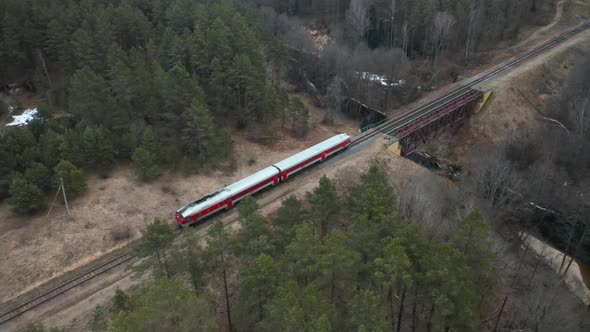 AERIAL: Old Red Train Rides Across Bridge Over River