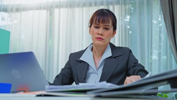Exhausted Asian businesswoman office worker busy and napping at workplace. alt