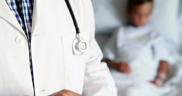 Male doctor using digital tablet during visit in ward alt