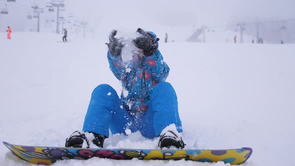 Cheerful Beautiful Young Girl Snowboarder Throws Snow Flakes