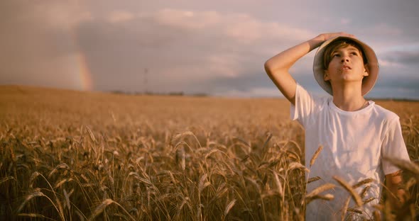 Funny Boy in a Hat Golden Wheat Field Looks at the Beautiful Sky at Sunset Before Storm Cinematic