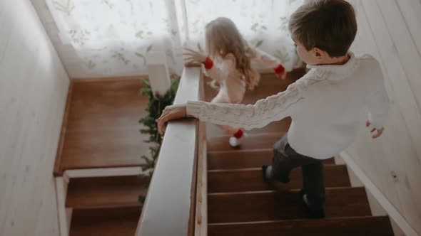Excited Boy and Girl are Running Down the Stairs on Christmas Morning