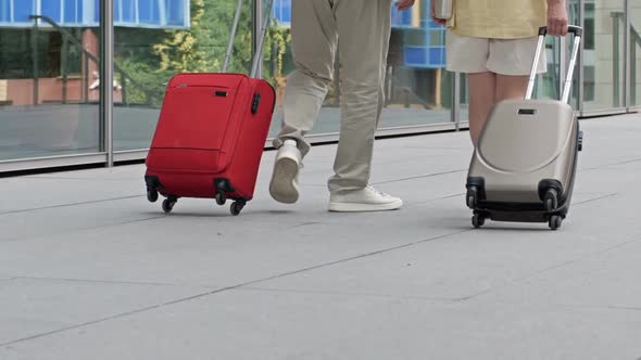 Couple with Suitcases Walking Through the Airport or Train Station alt