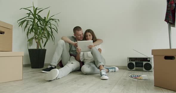 Young Couple in New Flat Using Digital Tablet alt